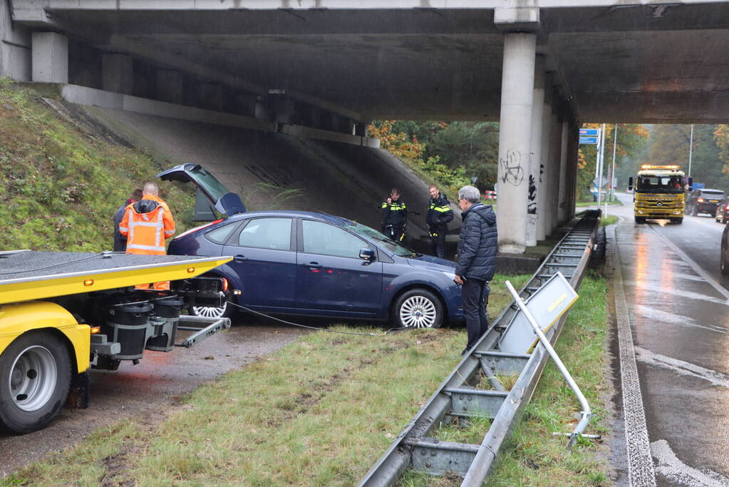 Auto vliegt over vangrail en belandt op kop