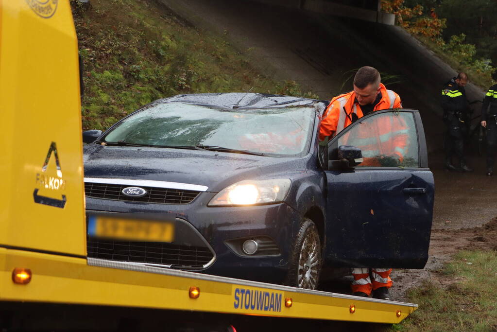 Auto vliegt over vangrail en belandt op kop