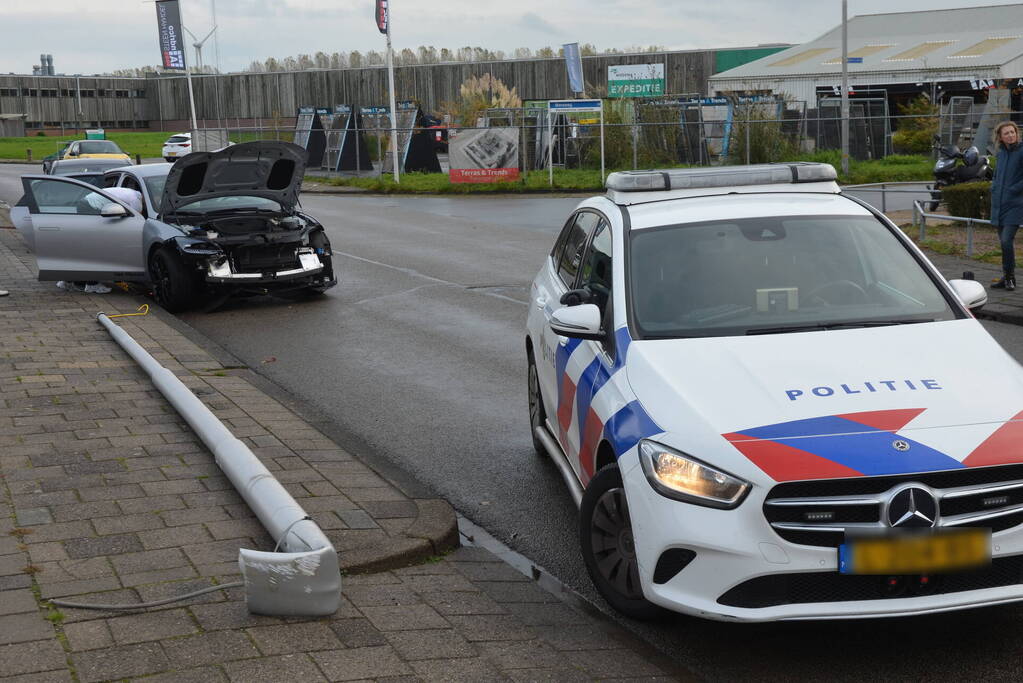 Personenauto klapt op lantaarnpaal