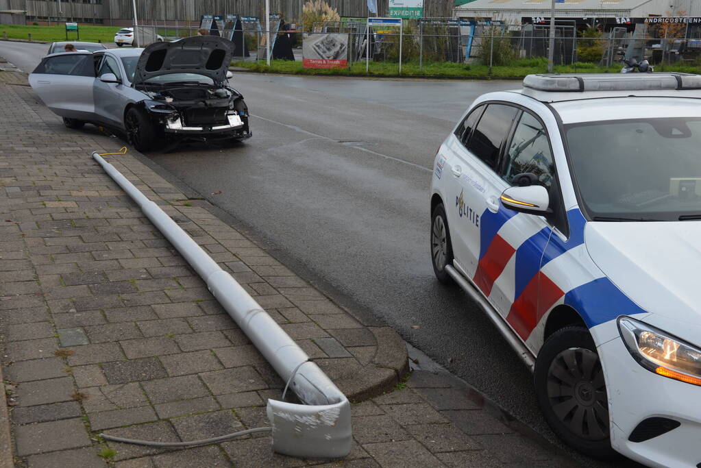 Personenauto klapt op lantaarnpaal