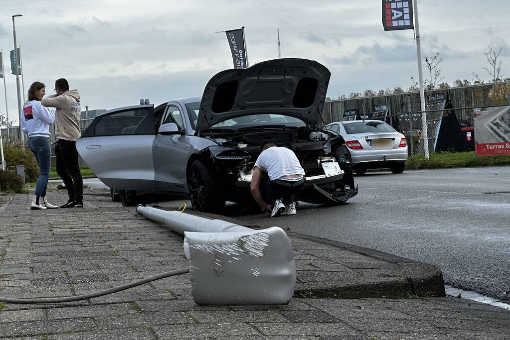 Personenauto klapt op lantaarnpaal