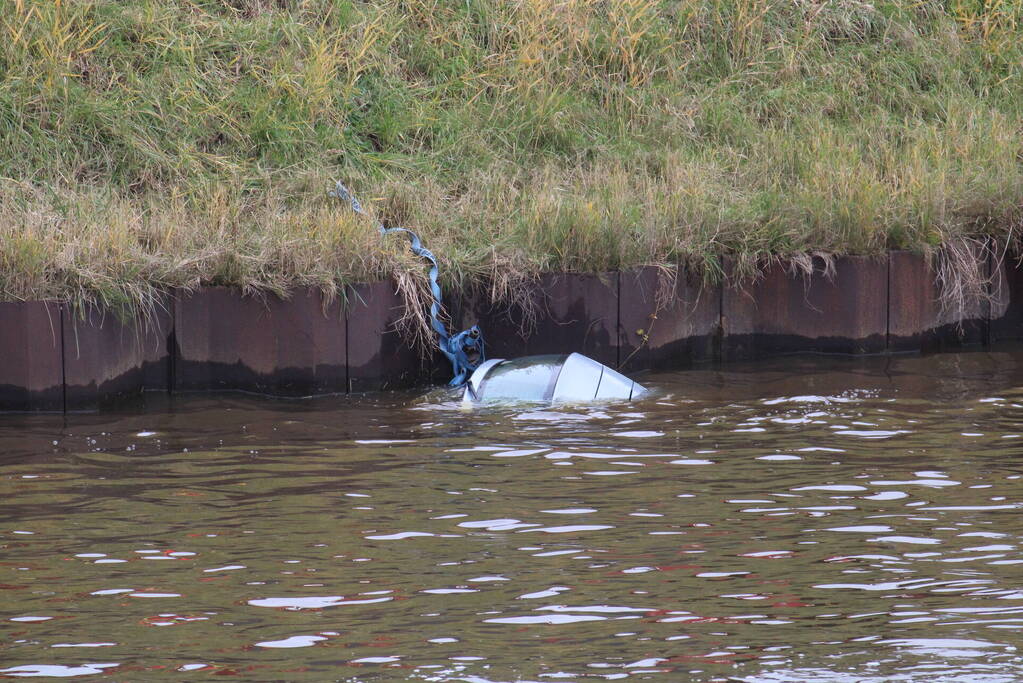 Personenauto rolt kanaal in