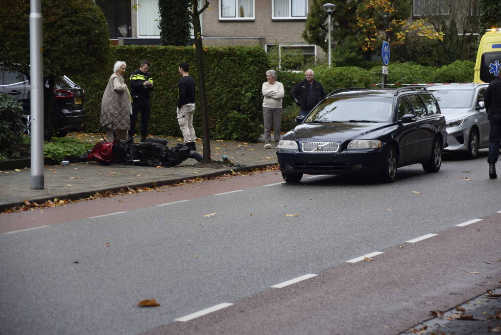 Overstekende scooter geschept door auto