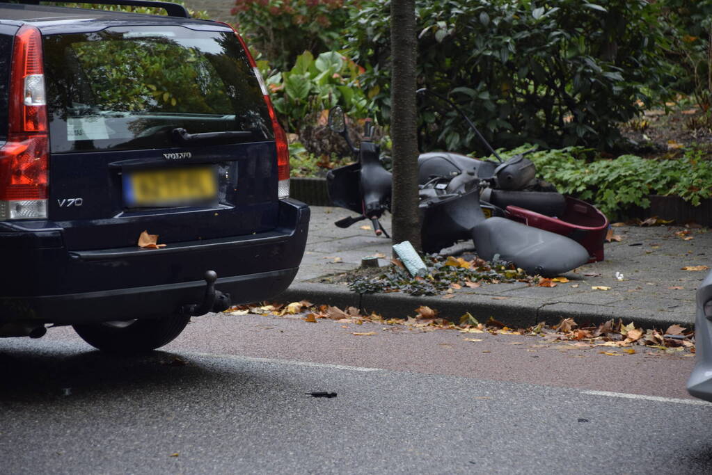 Overstekende scooter geschept door auto