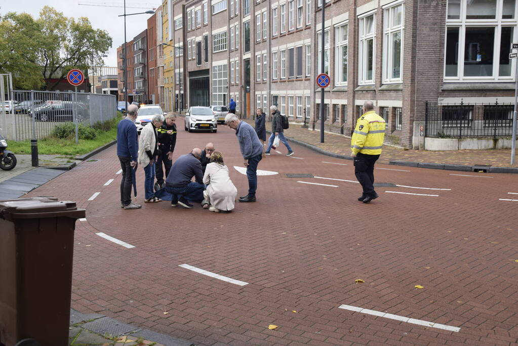 Persoon op scooter onderuit op kruising