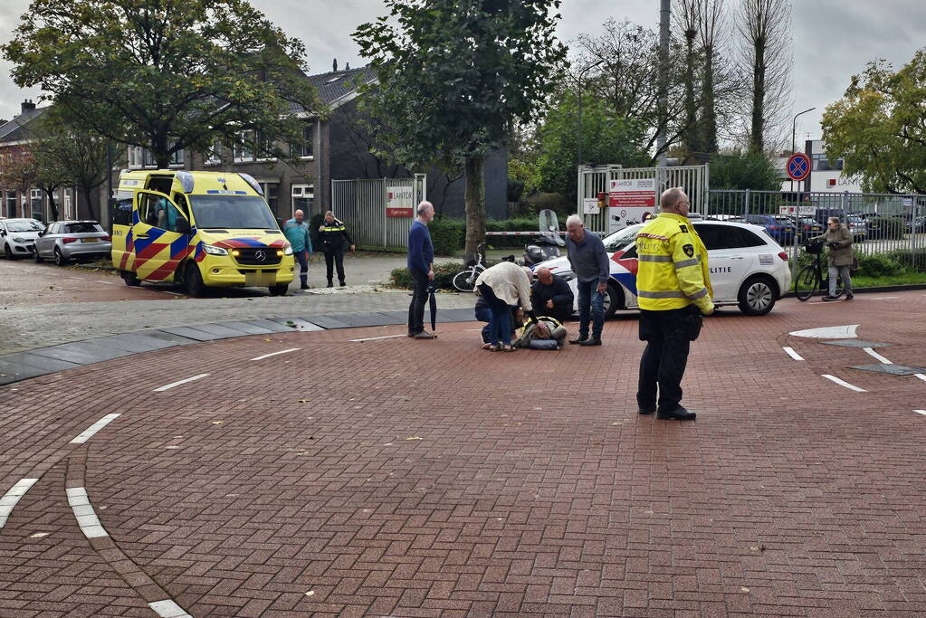 Persoon op scooter onderuit op kruising