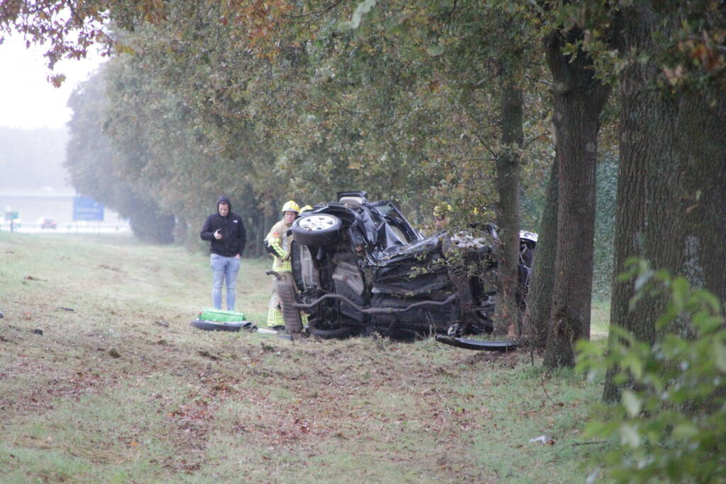 Auto zwaar beschadigd na botsing tegen boom langs snelweg