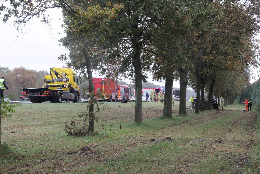 Auto zwaar beschadigd na botsing tegen boom langs snelweg