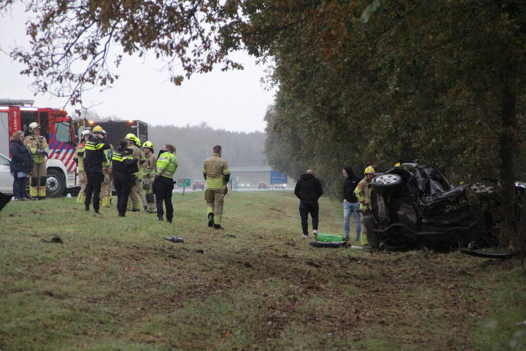 Auto zwaar beschadigd na botsing tegen boom langs snelweg