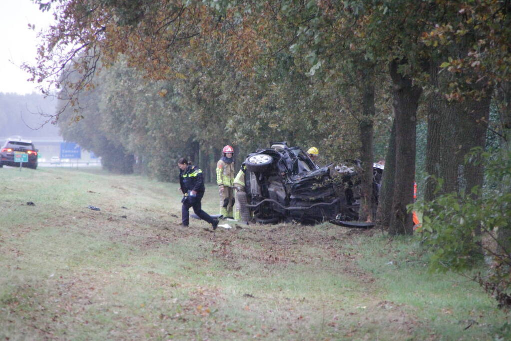 Auto zwaar beschadigd na botsing tegen boom langs snelweg