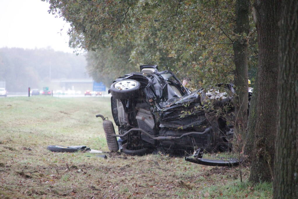 Auto zwaar beschadigd na botsing tegen boom langs snelweg