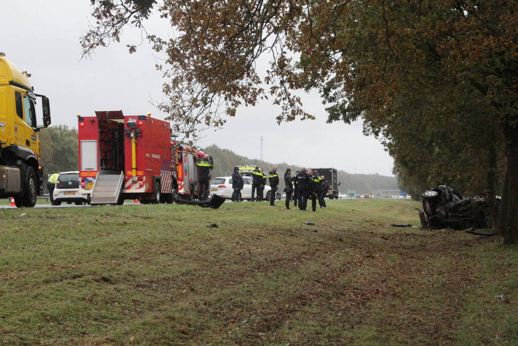 Auto zwaar beschadigd na botsing tegen boom langs snelweg