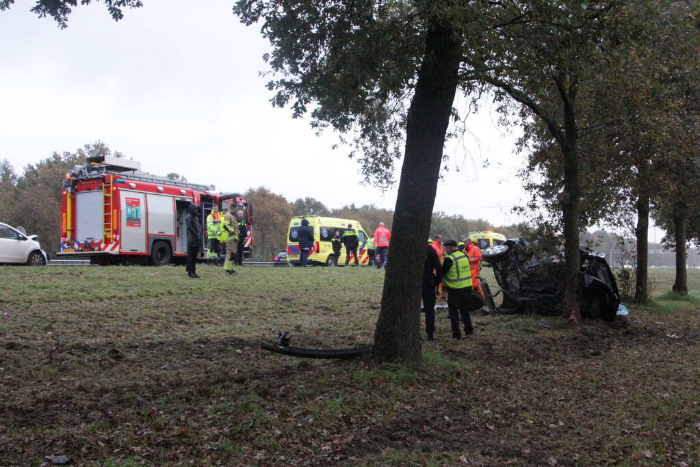 Auto zwaar beschadigd na botsing tegen boom langs snelweg