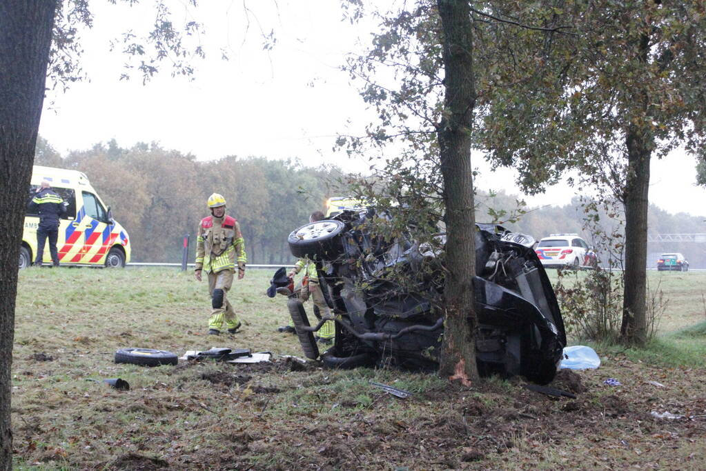 Auto zwaar beschadigd na botsing tegen boom langs snelweg