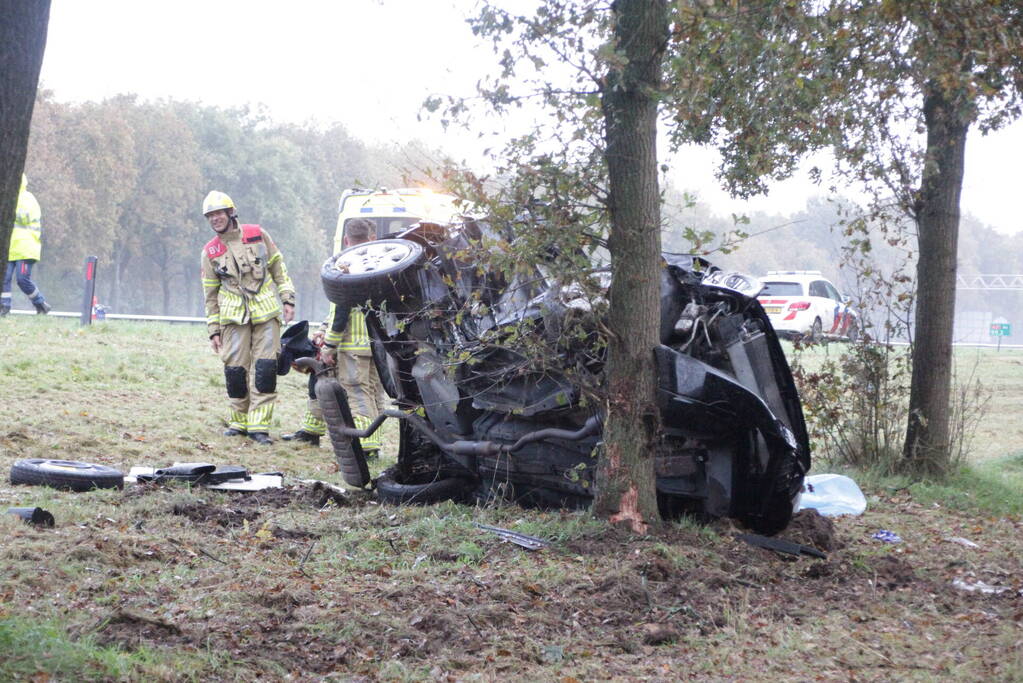 Auto zwaar beschadigd na botsing tegen boom langs snelweg