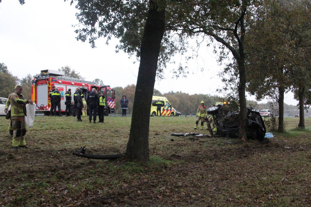 Auto zwaar beschadigd na botsing tegen boom langs snelweg