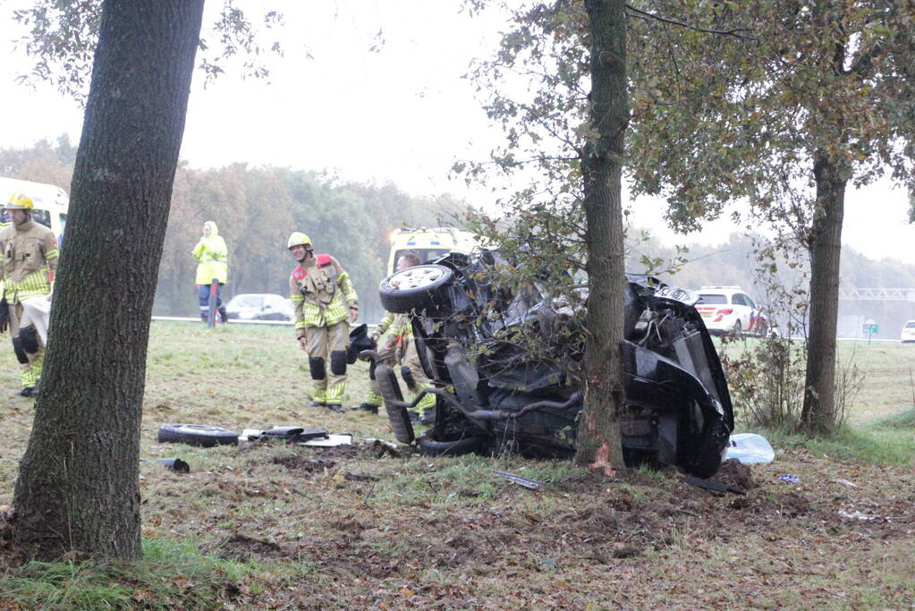 Auto zwaar beschadigd na botsing tegen boom langs snelweg