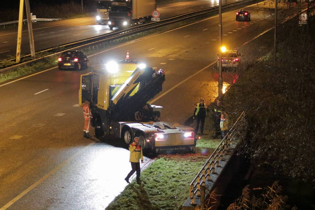 Auto belandt in water naast snelweg