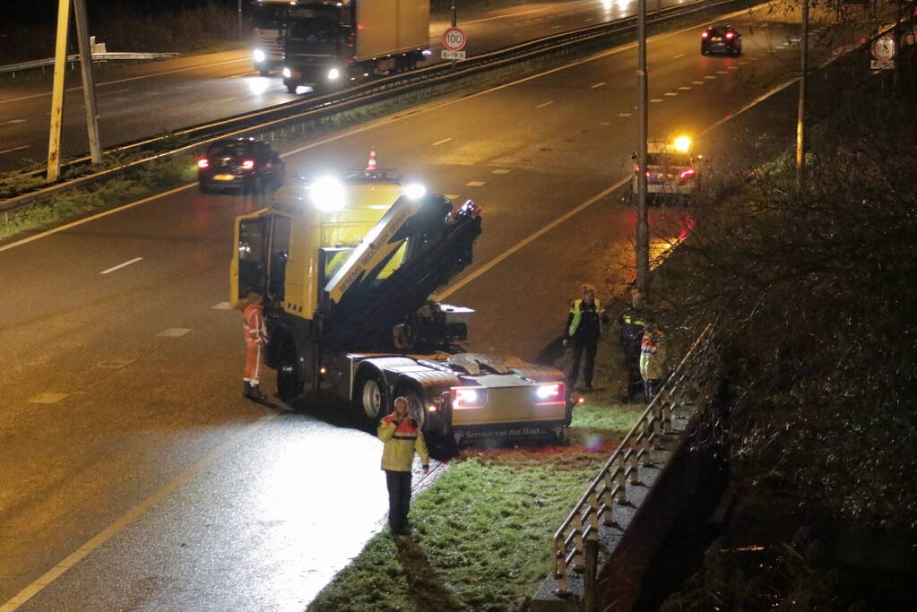 Auto belandt in water naast snelweg