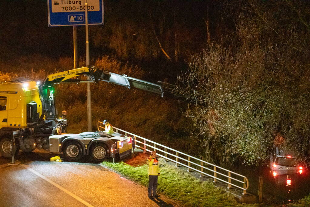 Auto belandt in water naast snelweg