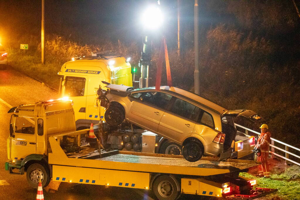 Auto belandt in water naast snelweg