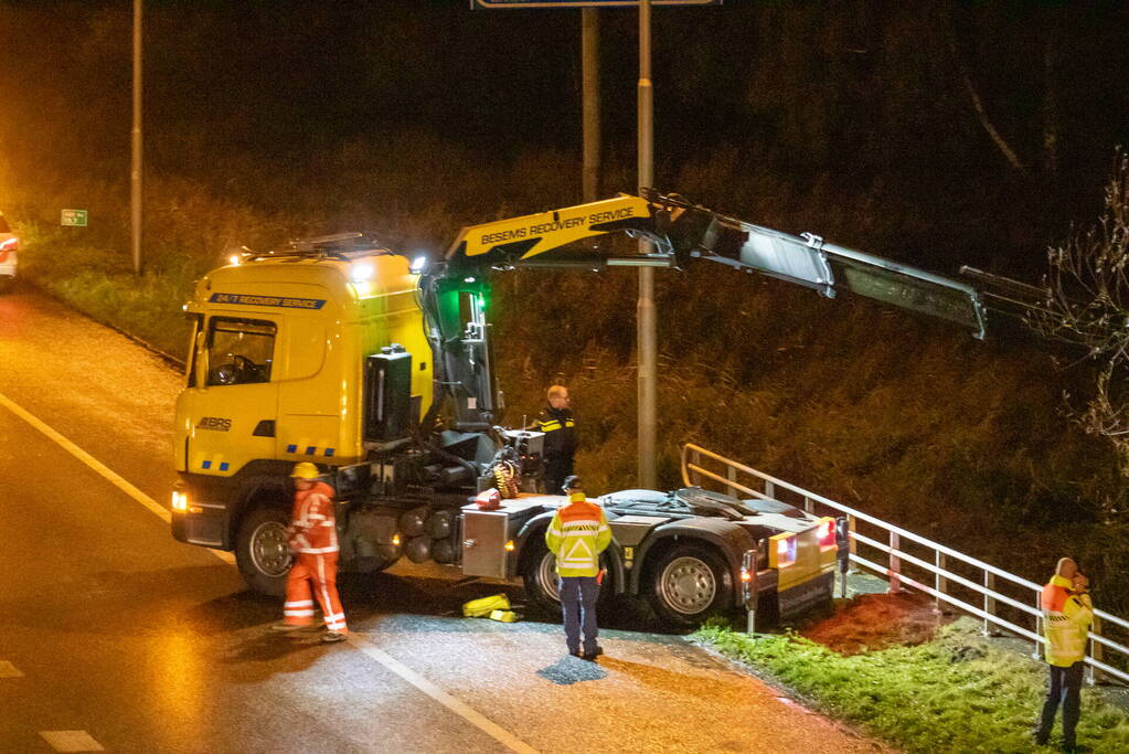 Auto belandt in water naast snelweg