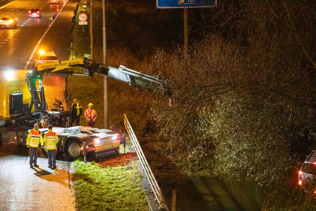 Auto belandt in water naast snelweg