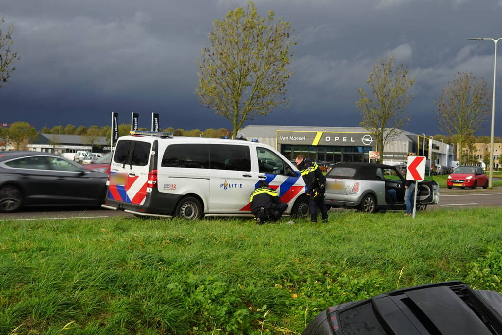 Omstanders halen inzittenden uit te water geraakt voertuig