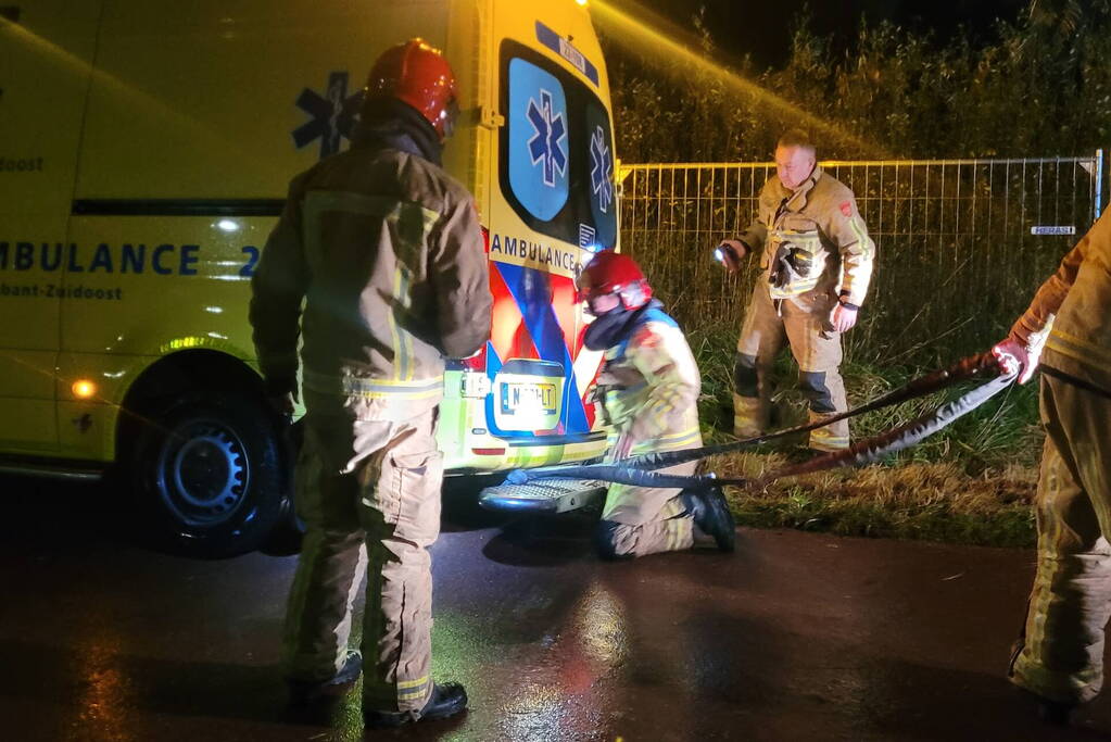 Brandweer trekt ambulance en auto uit modder