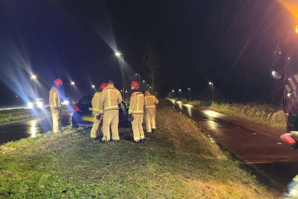 Brandweer trekt ambulance en auto uit modder