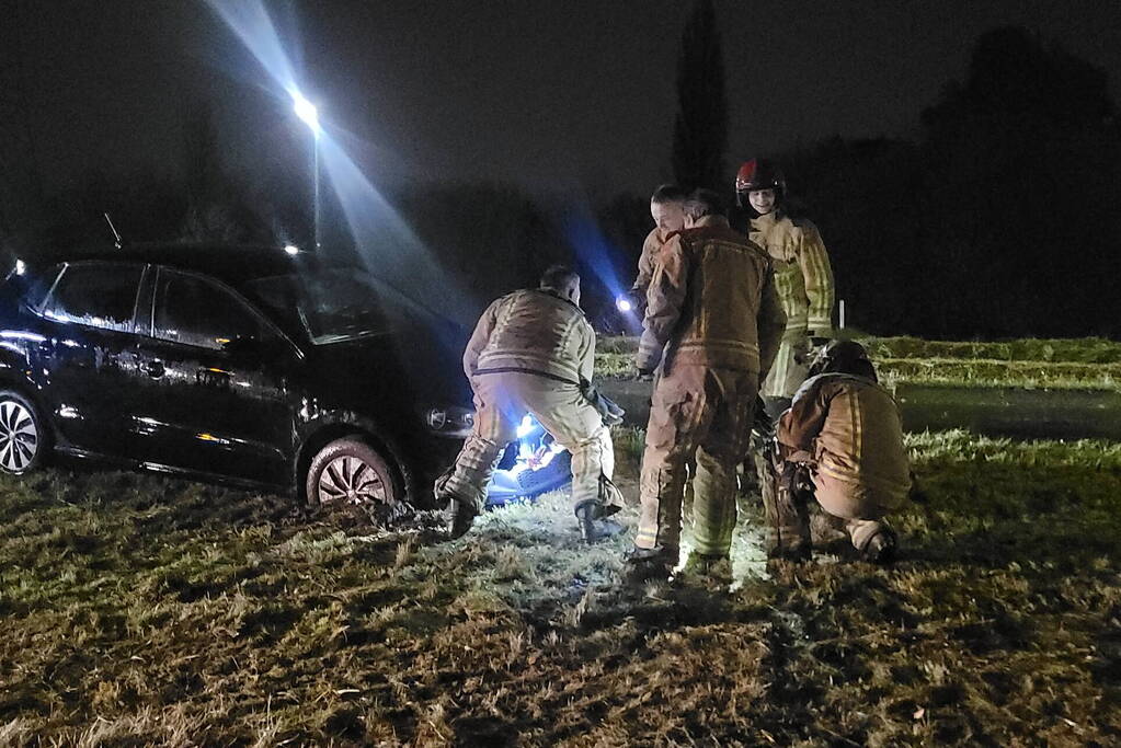 Brandweer trekt ambulance en auto uit modder