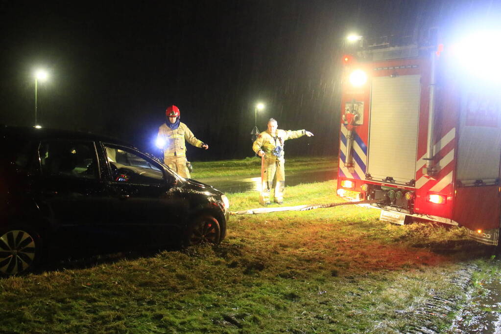 Brandweer trekt ambulance en auto uit modder