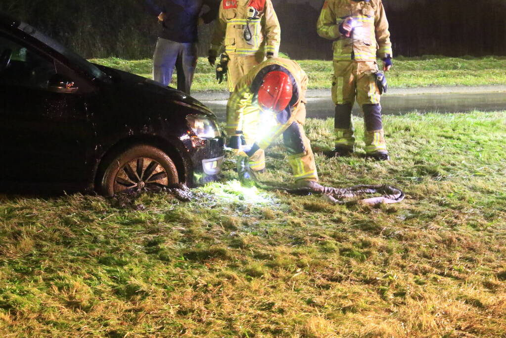 Brandweer trekt ambulance en auto uit modder