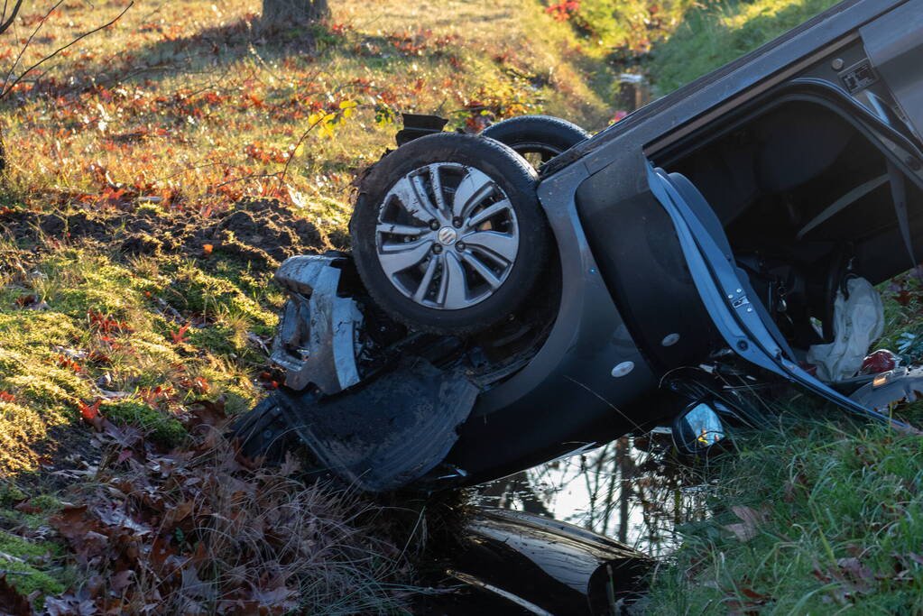 Auto op zijn kop na aanrijding met vrachtwagen