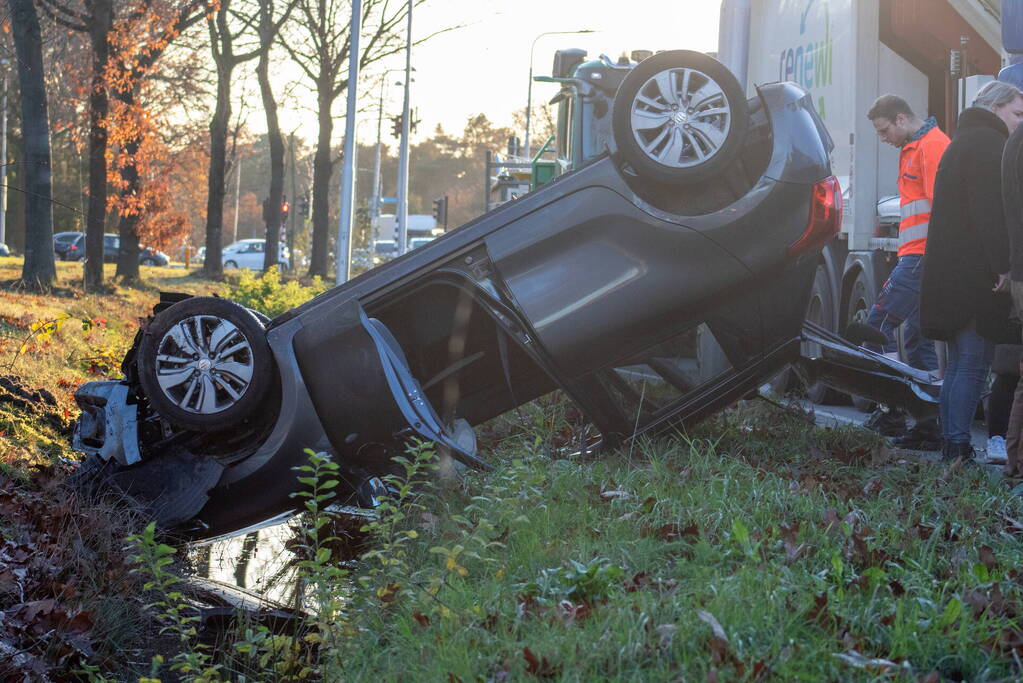 Auto op zijn kop na aanrijding met vrachtwagen