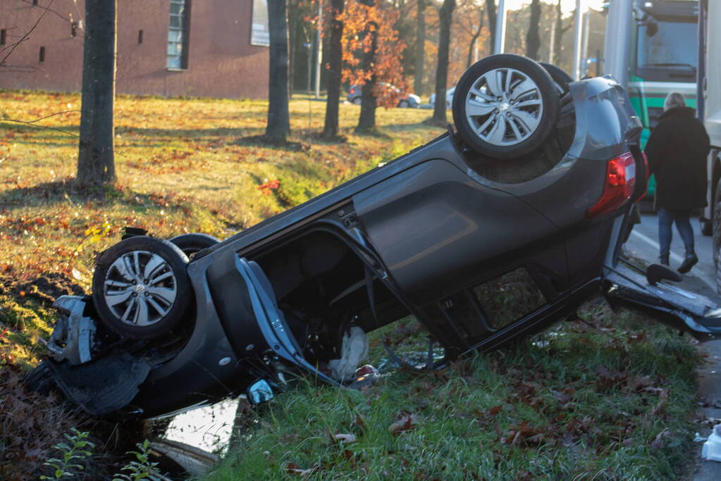 Auto op zijn kop na aanrijding met vrachtwagen