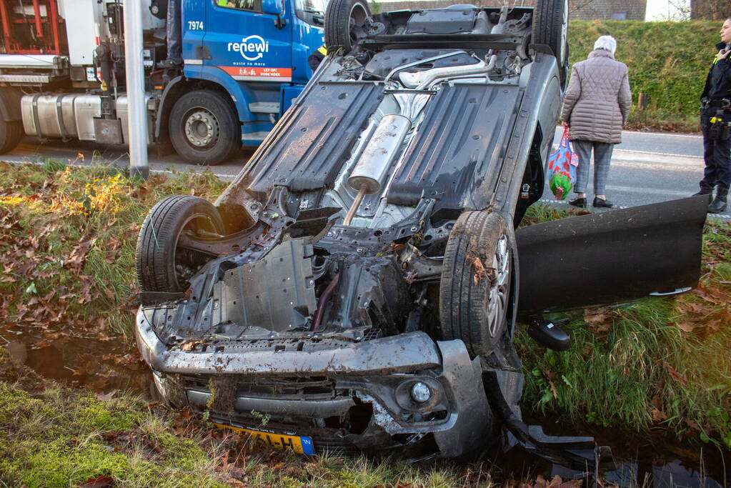 Auto op zijn kop na aanrijding met vrachtwagen