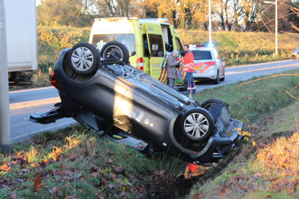 Auto op zijn kop na aanrijding met vrachtwagen