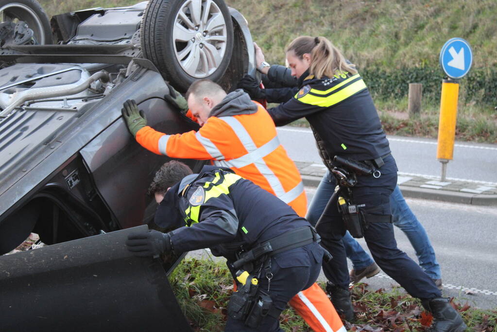 Auto op zijn kop na aanrijding met vrachtwagen