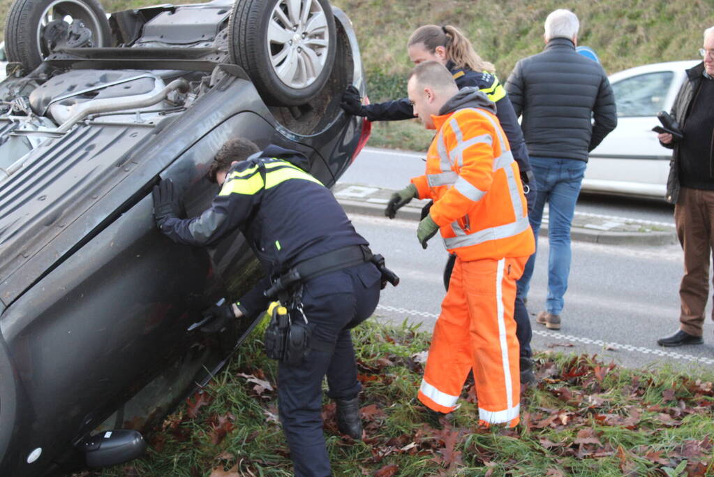 Auto op zijn kop na aanrijding met vrachtwagen