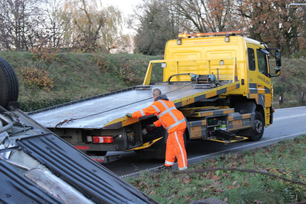 Auto op zijn kop na aanrijding met vrachtwagen