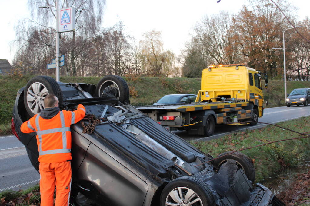 Auto op zijn kop na aanrijding met vrachtwagen