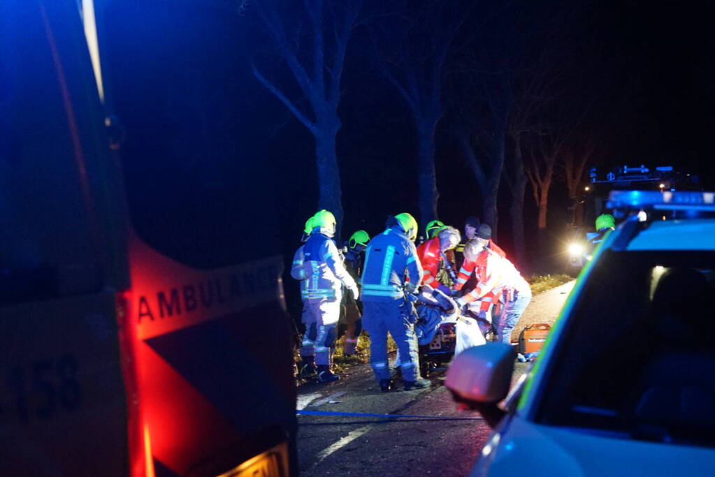 Auto zwaar beschadigd na frontale botsing tegen boom, bestuurder zwaargewond