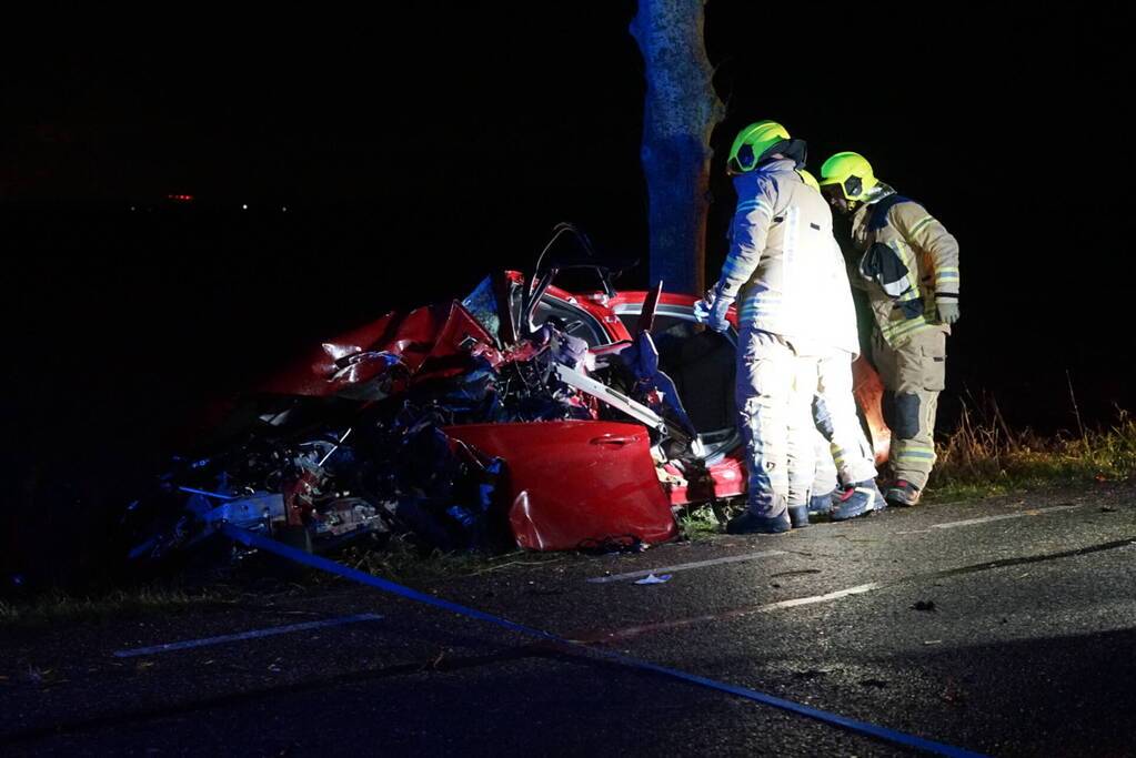 Auto zwaar beschadigd na frontale botsing tegen boom, bestuurder zwaargewond