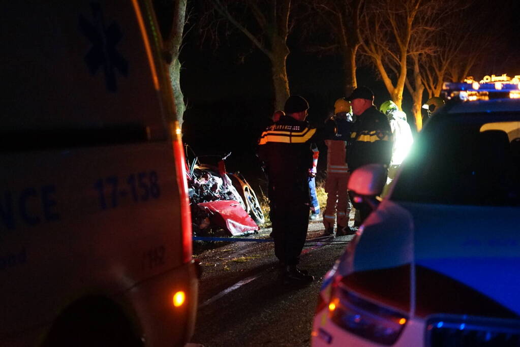 Auto zwaar beschadigd na frontale botsing tegen boom, bestuurder zwaargewond