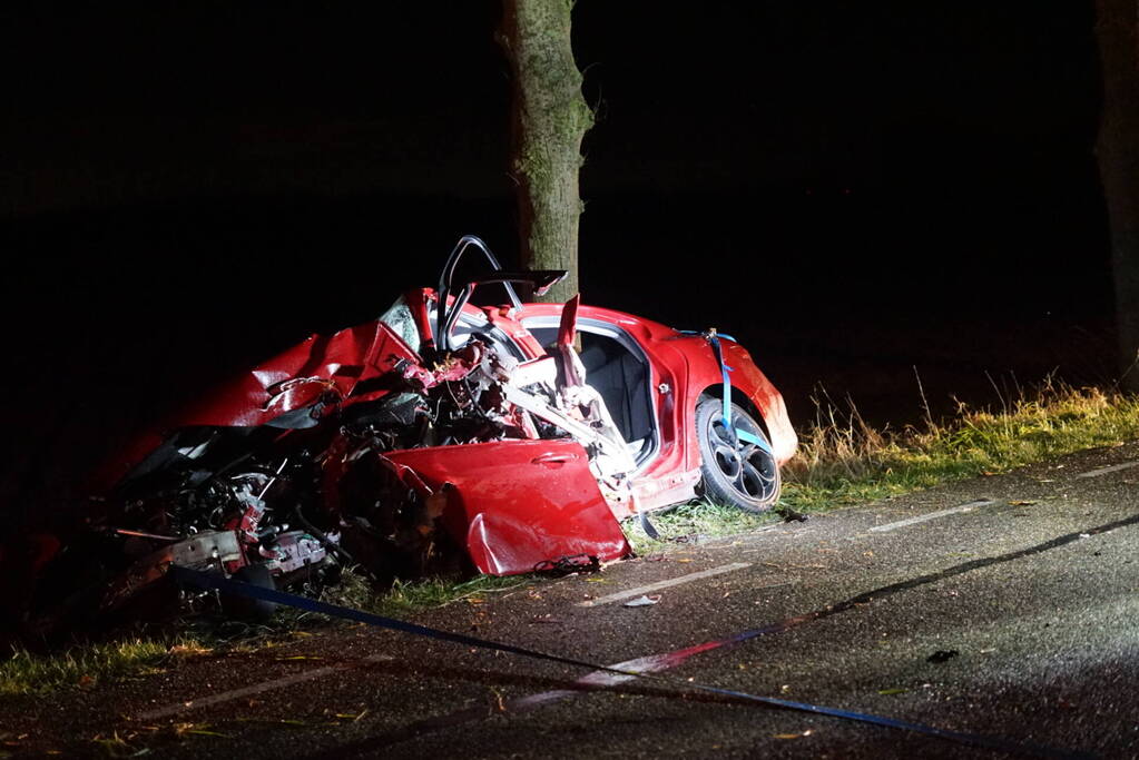 Auto zwaar beschadigd na frontale botsing tegen boom, bestuurder zwaargewond