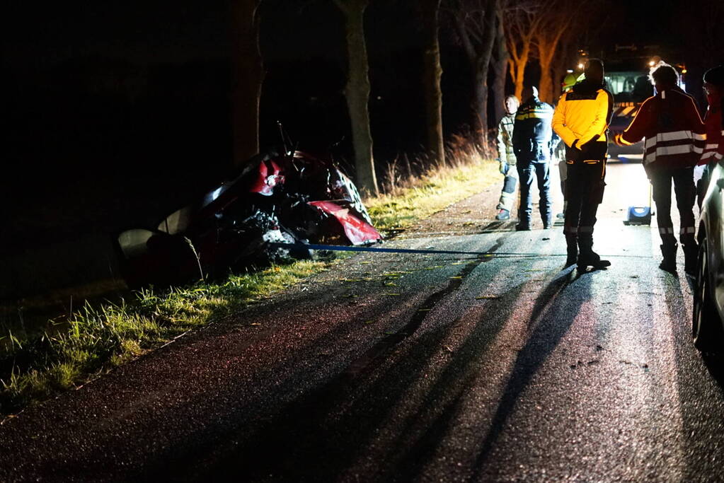 Auto zwaar beschadigd na frontale botsing tegen boom, bestuurder zwaargewond