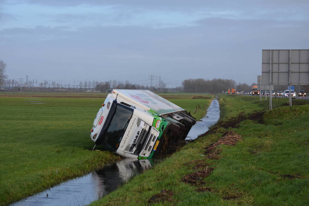 Vrachtwagen gekanteld in sloot naast snelweg