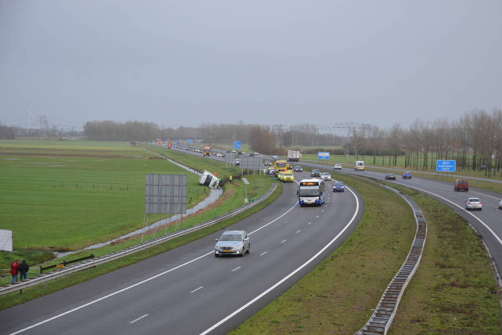 Vrachtwagen gekanteld in sloot naast snelweg