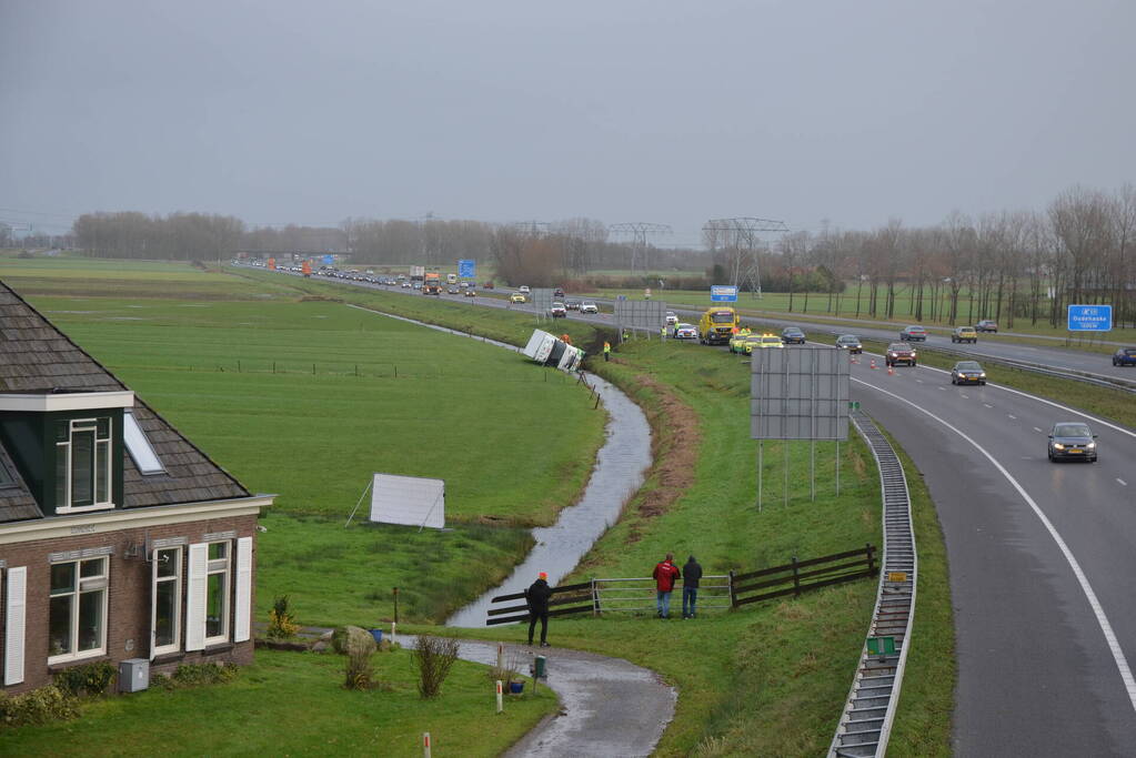 Vrachtwagen gekanteld in sloot naast snelweg